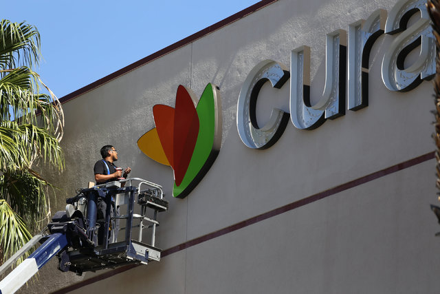 A worker hangs a sign for Curacao, a new tenant at Meadows mall in Las Vegas on Thursday, Sept. 15, 2016. (Brett Le Blanc/Las Vegas Review-Journal Follow @bleblancphoto)
