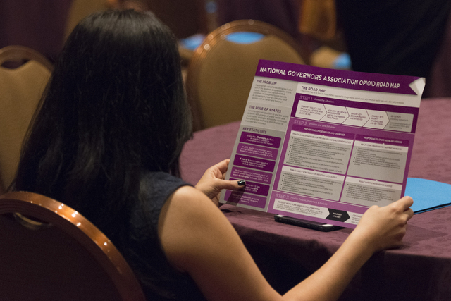 A woman views the National Governors Association Opioid Road Map during Gov. Brian Sandoval's Prescription Drug Abuse Prevention Summit at MGM Grand hotel-casino in Las Vegas, Wednesday, Aug. 31,  ...