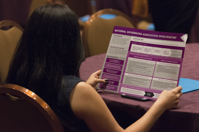 A woman views the National Governors Association Opioid Road Map during Gov. Brian Sandoval's Prescription Drug Abuse Prevention Summit at MGM Grand hotel-casino in Las Vegas, Wednesday, Aug. 31, ...