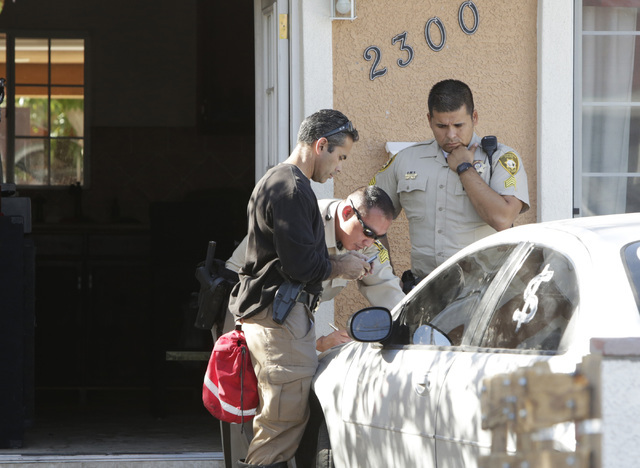 Metro police officers check residents identifications outside a house where one man died after a fire at 2300 Dori Ave., on Wednesday, Sept. 14, 2016. (Bizuayehu Tesfaye/Las Vegas Review-Journal F ...