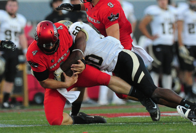 UNLV Rebels quarterback Johnny Stanton (4) is sacked by Idaho Vandals linebacker Ed Hall (50) in the first half of their NCAA college football game at Sam Boyd Stadium in Henderson Saturday, Sept. ...