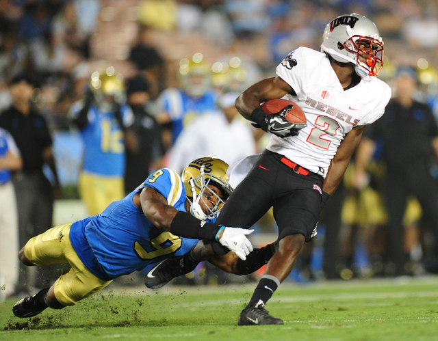 UCLA Bruins defensive back Marcus Rios (9) tackles UNLV Rebels wide receiver Mekhi Stevenson (2) in the second half of their NCAA college football game at the Rose Bowl in Pasadena, Calif. Saturda ...