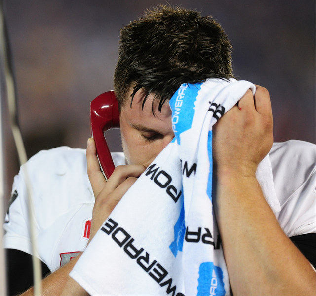 UNLV Rebels quarterback Johnny Stanton (4) wipes sweat off his head while talking to the offensive coordinator in the second half of their NCAA college football game against UCLA at the Rose Bowl ...