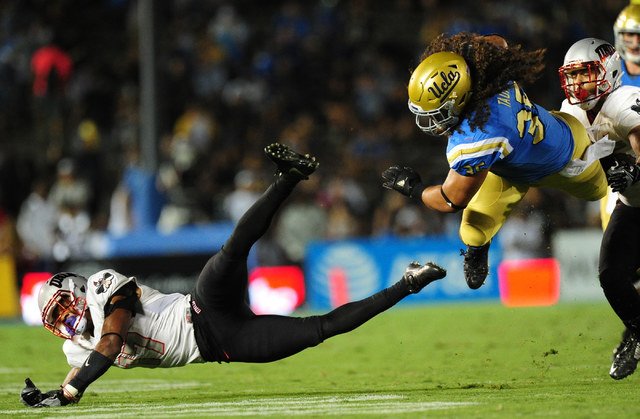 UNLV Rebels defensive back Evan Austrie (17) tackles UCLA Bruins fullback Ainuu Taua (35) after Taua made a first down reception in the second half of their NCAA college football game at the Rose  ...