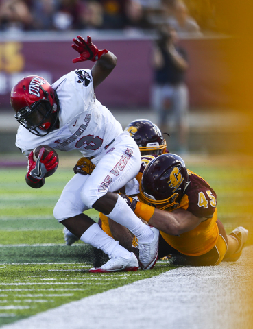 UNLV running back Lexington Thomas (3) is taken down by Central Michigan defense, including defensive lineman Joe Ostman (45), during a football game at Kelly/Shorts Stadium in Mount Pleasant, Mic ...