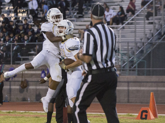 Faith Lutheran wide receiver Justin Taylor (81) celebrates with teammate Saundre Spiller (20) after scoring a first quarter touchdown during the Crusaders road matchup with the Skyhawks on Friday, ...
