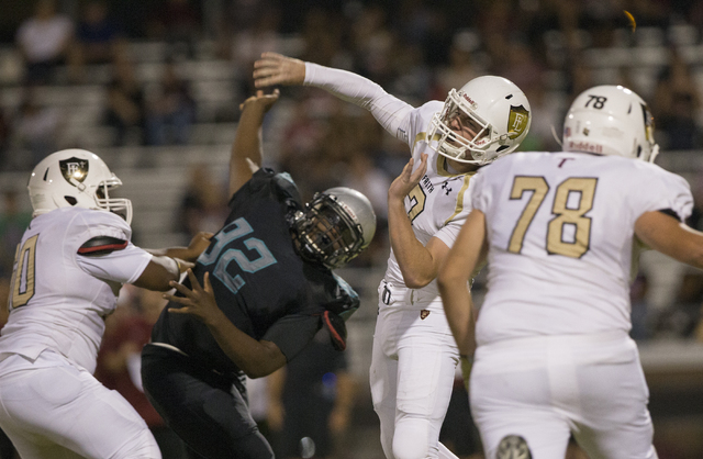 Faith Lutheran quarterback Sagan Gronauer (7) gets a pass off in traffic during the Crusaders road matchup with the Skyhawks on Friday, Sept. 16, 2016, at Silverado High School, in Las Vegas. Benj ...