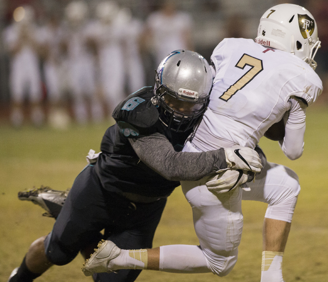 Faith Lutheran quarterback Sagan Gronauer (7) is tackled by Silverado linebacker Joshua Lathers (6) during the Crusaders road matchup with the Skyhawks on Friday, Sept. 16, 2016, at Silverado High ...