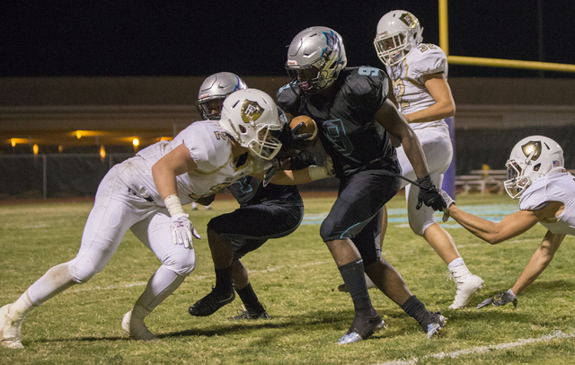 Silverado running back Nahzi Salih (9) fights for extra yardage with Faith Lutheran defenders during the Skyhawks home matchup with the Crusaders on Friday, Sept. 16, 2016, at Silverado High Schoo ...