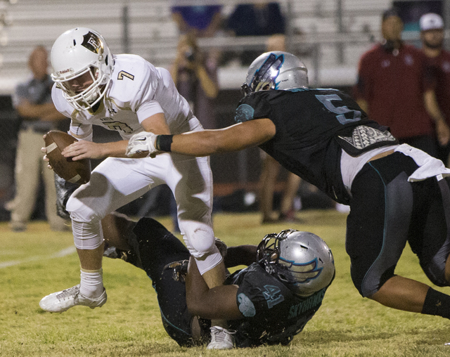 Faith Lutheran quarterback Sagan Gronauer (7) is sacked by Silverado defenders Christopher-James Liana (5) and Myron Mingo (41) during the Crusaders road matchup with the Skyhawks on Friday, Sept. ...