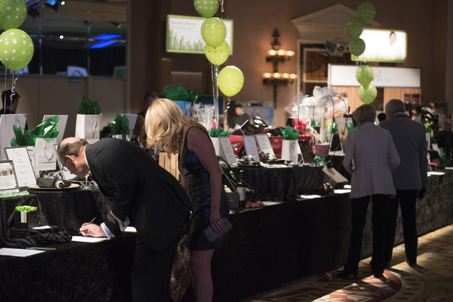 Guests participate in the silent auction during the Girl Scouts of Southern Nevada &quot;Dessert Before Dinner&quot; charity event at Caesars Palace hotel-casino in Las Vegas, Saturday, Se ...