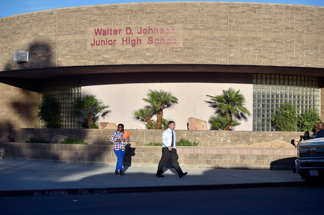 A student walks with an administrator after being released from Johnson Junior High School Wednesday, Sept. 7, 2016, in Las Vegas. A hazardous material, suspected to be mercury, was found in the s ...