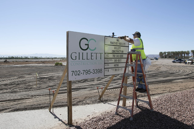 Gillette Construction Manager Brad Seller installs the dust control permit sign at the site of the headquarters and practice facility for Las Vegas's HNL expansion team on Pavilion Center Drive ac ...