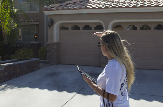 Americans for Prosperity Field Director Erinn Mahathey looks for an address on a residence as she walks door-to-door while canvassing a neighborhood for the organization in west Las Vegas on Monda ...