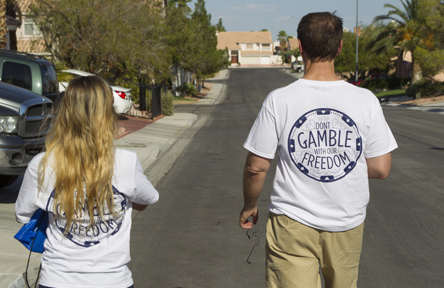 Tim Phillips, right, president of Americans for Prosperity and Field Director Erinn Mahathey walk door-to-door while canvassing a neighborhood for the organization in west Las Vegas on Monday, Aug ...