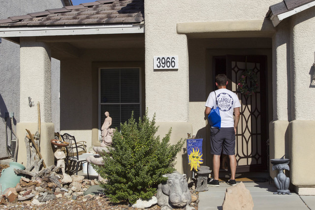 Americans for Prosperity volunteer Roger Pattison speaks to a woman while going door-to-door for the organization in a neighborhood in west Las Vegas on Monday, Aug. 29, 2016. (Richard Brian/Las V ...