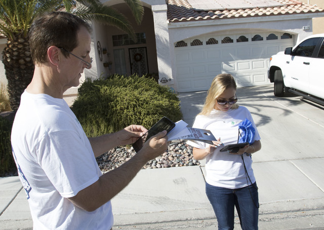 Tim Phillips, left, president of Americans for Prosperity and Field Director Erinn Mahathey update their routes on a tablet while canvassing a neighborhood for the organization in west Las Vegas o ...