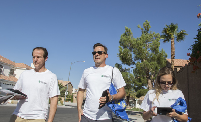 Tim Phillips, left, president of Americans for Prosperity, is joined by Field Director Erinn Mahathey, right and volunteer Roger Pattison as they canvass a neighborhood for the organization in wes ...