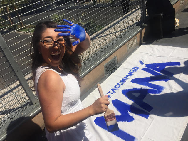 A passerby displays her paint-covered hand during an event on the Las Vegas Strip on Sept. 16, 2016. The handprints symbolize passersby's intent to vote, and a man yelling racial slurs at voluntee ...