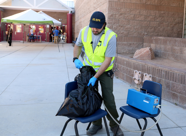 Randy Nattis, federal on-site coordinator for the EPA, demonstrates how students' belongs are tested for mercury contamination during at news conference at Johnson Junior High School in Las Vegas  ...