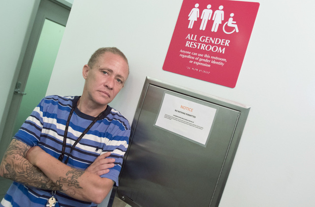 Blue Montana, transgender program manager for the Gay and Lesbian Community Center of Southern Nevada (The Center), 401 S. Maryland Parkway, stands next to a restroom sign welcoming all genders on ...