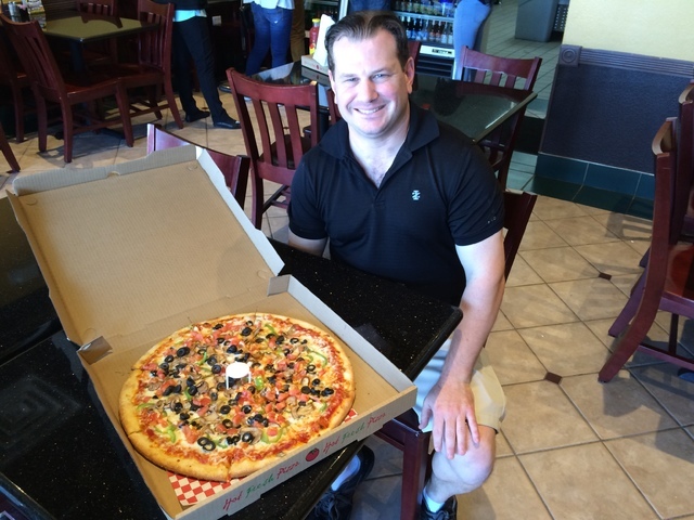Jason Faber, owner/operator of Papa Pinny's Pizza, 8125 W. Sahara Ave., Suite 170, shows off one of his pizzas July 15. The pizza eatery is named for his late grandfather, Papa Pinny. Jan Hogan/View