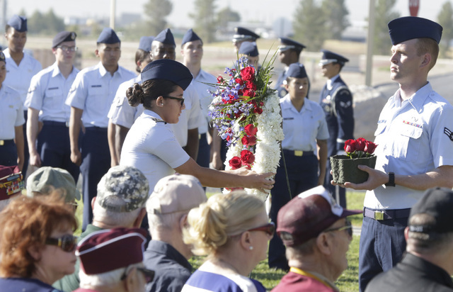 An Air Force Junior ROTC cadet from Rancho High School places a red rose in a wreath during the annual National POW-MIA Recognition Day ceremony Friday, Sept 16, 2016, at Nellis Air Force Base. Bi ...