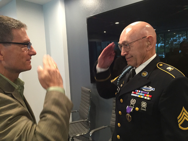 Army Korean War veteran Warren Sessler salutes Rep. Joe Heck, who is an Army Reserve brigadier general, after Heck presented him with a Purple Heart medal following a veterans meeting in Henderson ...
