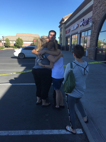(Rachel Hershkovitz/Las Vegas Review-Journal)
Will Wright, 19, hugs his mother and sister after being released by police. Wright was working the cash register in the Starbucks when the shooting began.