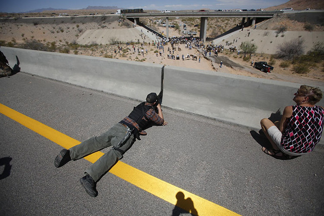 Eric Parker from central Idaho aims his weapon from a bridge as protesters gather by the Bureau of Land Management's (BLM) base camp, where cattle that were seized from rancher Cliven Bundy are be ...