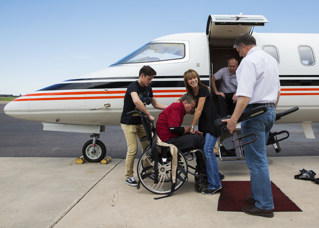 Sam Schmidt, middle, is helped off a charter flight by wife Sheila, right, and son Spencer on Thursday, June 9, 2016, in Colorado Springs, Colo. Schmidt, owner of IndyCar team Schmidt Peterson Mot ...