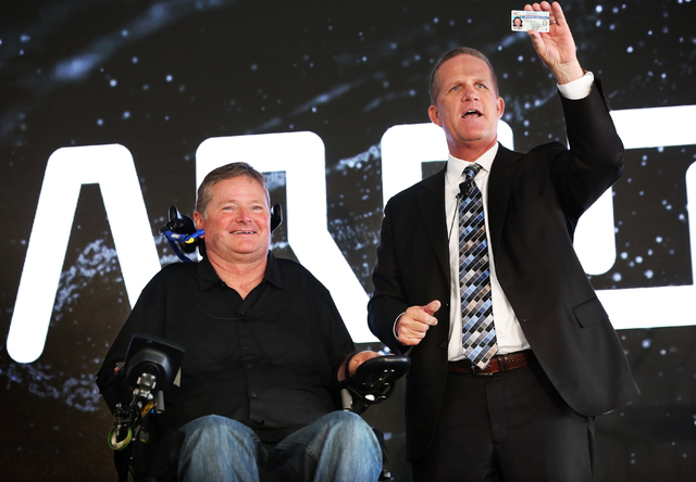 Sam Schmidt, left, celebrates getting his driver's license with Nevada Lieutenant Governor Mark Hutchison at Exotics Racing on Wednesday, Sept. 28, 2016, in Las Vegas. Schmidt is the first person  ...