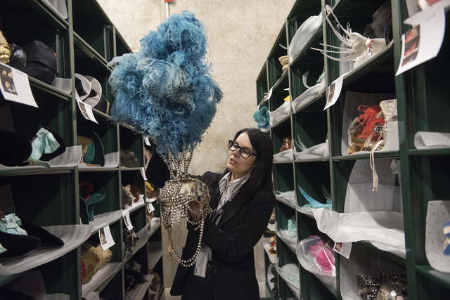 Karan Feder, guest curator of costumes and textiles at the Nevada State Museum, holds a head dress from "The Les Folies Bergere" exhibit at the Nevada State Museum Aug. 27. Martin S. Fuentes/View