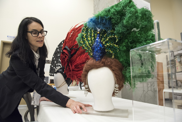 Karan Feder, guest curator of costumes and textiles, handles a head dress from "The Les Folies Bergere" exhibit at the Nevada State Museum Aug. 27. Martin S. Fuentes/View