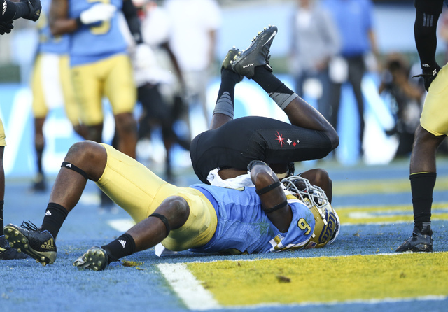 UNLV Rebels wide receiver Mekhi Stevenson (2) falls to the ground over UCLA Bruins defensive back Adarius Pickett (6) after catching a touchdown pass during a football game at the Rose Bowl in Pas ...