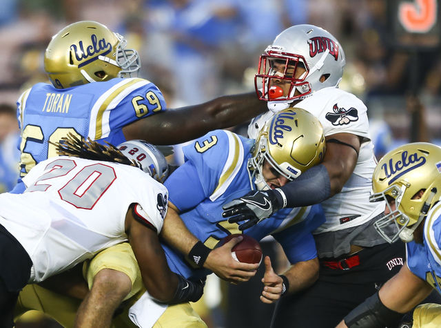 UNLV players, including linebacker LaKeith Walls (20), take down UCLA Bruins quarterback Josh Rosen (3) during a football game at the Rose Bowl in Pasadena, Calif. on Saturday, Sept. 10, 2016. UCL ...