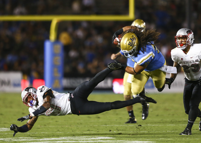 UCLA Bruins fullback Ainuu Taua (35) dodges a tackle from UNLV Rebels defensive back Evan Austrie (17) during a football game at the Rose Bowl in Pasadena, Calif. on Saturday, Sept. 10, 2016. UCLA ...