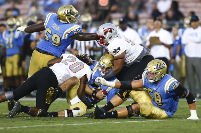 UNLV players, including linebacker LaKeith Walls (20), take down UCLA Bruins quarterback Josh Rosen (3) during a football game at the Rose Bowl in Pasadena, Calif. on Saturday, Sept. 10, 2016. UCL ...
