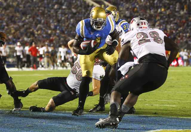 UCLA Bruins running back Bolu Olorunfunmi (4) scores a touchdown against UNLV during a football game at the Rose Bowl in Pasadena, Calif. on Saturday, Sept. 10, 2016. UCLA won 42-21. Chase Stevens ...