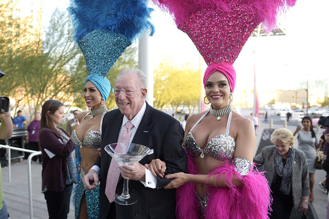 Former Las Vegas Mayor Oscar Goodman is escorted by showgirls Jennifer Johnson, left, and Porsha Viger during the dedication of Oscar B. Goodman Plaza in front of Las Vegas City Hall Wednesday, Oc ...