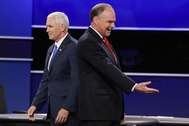 Republican vice-presidential nominee Gov. Mike Pence and Democratic vice-presidential nominee Sen. Tim Kaine, right, walk past each other after the vice-presidential debate at Longwood University ...