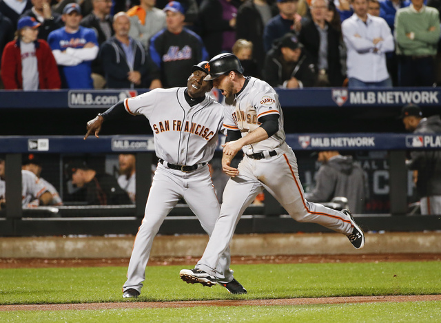 San Francisco Giants third baseman Conor Gillaspie (21) is congratulated by third base coach Roberto Kelly (39) as he rounds the bases after hitting a home run against the New York Mets during the ...