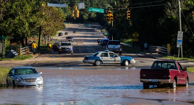 Abandoned cars sit in flood waters on Atlantic Avenue near Crabtree Creek in Raleigh, N.C., after Hurricane Matthew caused downed trees and flooding Sunday, Oct. 9, 2016. (Travis Long/The News &am ...