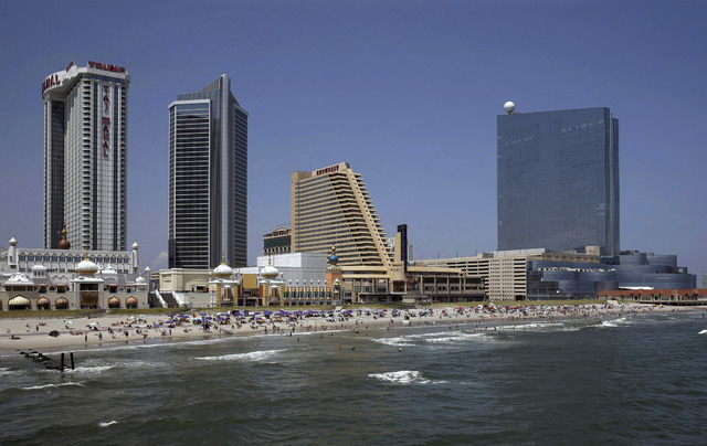 The Revel Casino Hotel, right, stands along the Boardwalk near Trump Taj Mahal Casino, left, with its Chairman Tower, and the Showboat Casino Hotel, second right, in Atlantic City, N.J., July 23, ...