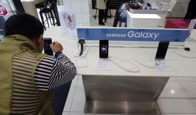 A visitor tries the Samsung Electronics' S7 edge smartphone at a shop of South Korean mobile carrier in Seoul, South Korea, Thursday, Oct. 13, 2016. (Lee Jin-man/AP)