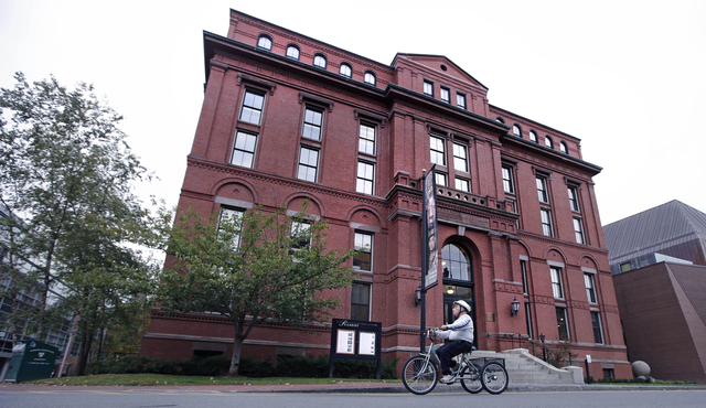 A cyclist earlier this month rolls past the Peabody Museum of Archaeology & Ethnology at Harvard University in Cambridge, Massachusetts. The Peabody, one of the oldest and largest museums in t ...