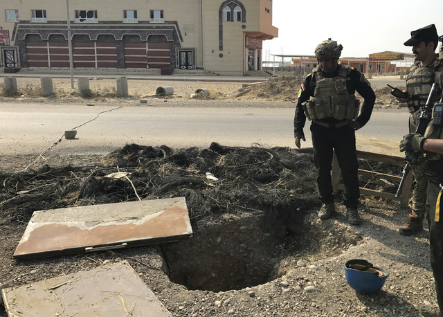 A soldier with Iraq's elite counterterrorism force inspects a tunnel made by Islamic State militants in Bartella, Iraq, Thursday, Oct. 27, 2016. The town of Bartella in northern Iraq lays about 20 ...