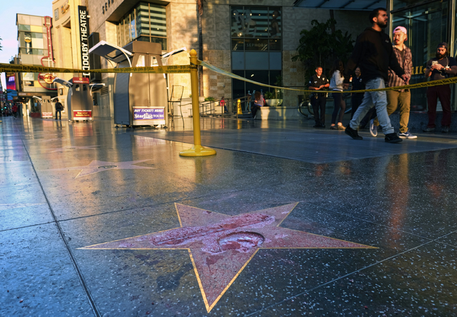 Pedestrians walk past a cordoned off area surrounding the vandalized star for Republican presidential candidate Donald Trump on the Hollywood Walk of Fame, Wednesday, Oct. 26,2016, in Los Angeles. ...