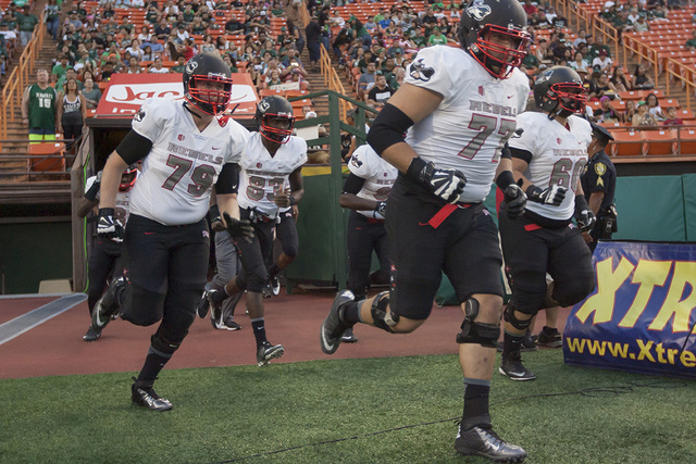 UNLV offensive lineman Michael Chevalier (77) and teammates take the field for an NCAA college football game against Hawaii, Saturday, Oct. 15, 2016, in Honolulu. (Eugene Tanner/AP)