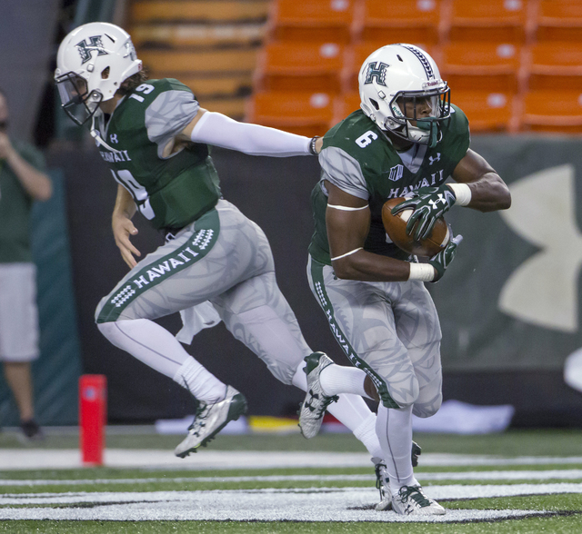 Hawaii quarterback Dru Brown (19) hands off to running back Paul Harris (6) during the first quarter of an NCAA college football game against UNLV, Saturday, Oct. 15, 2016, in Honolulu. (Eugene Ta ...
